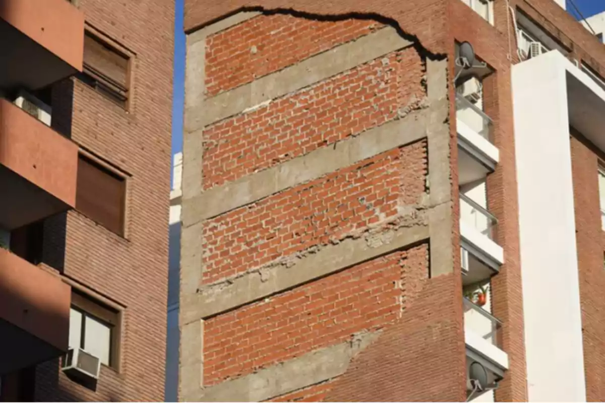 Brick building with an unfinished side wall that exposes the interior of the apartments and balconies