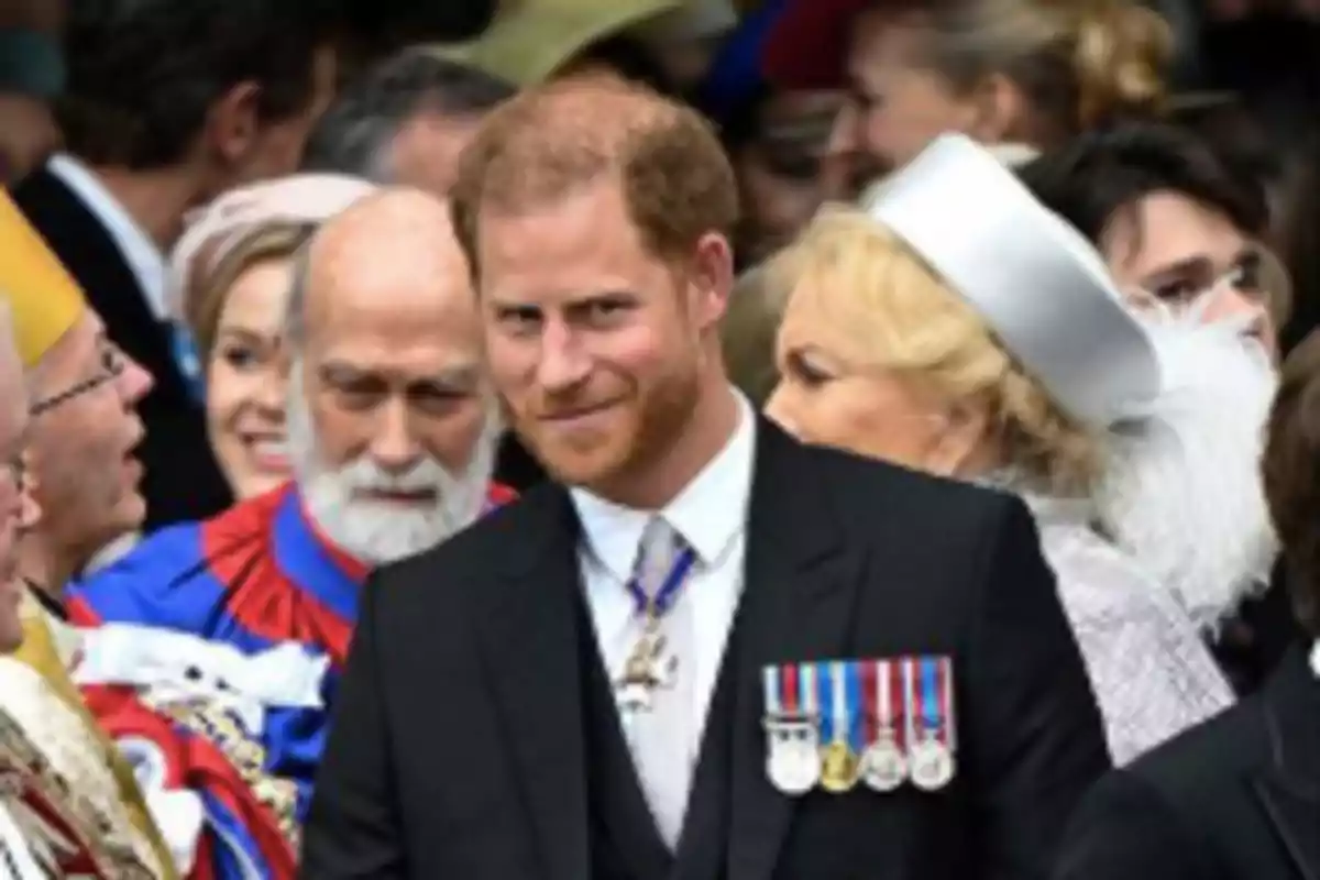 Hombre pelirrojo con barba y medallas en el pecho vestido de traje oscuro en un evento formal rodeado de otras personas elegantemente vestidas Hombre pelirrojo con barba y medallas en el pecho vestido de traje oscuro en un evento formal rodeado de otras personas elegantemente vestidas