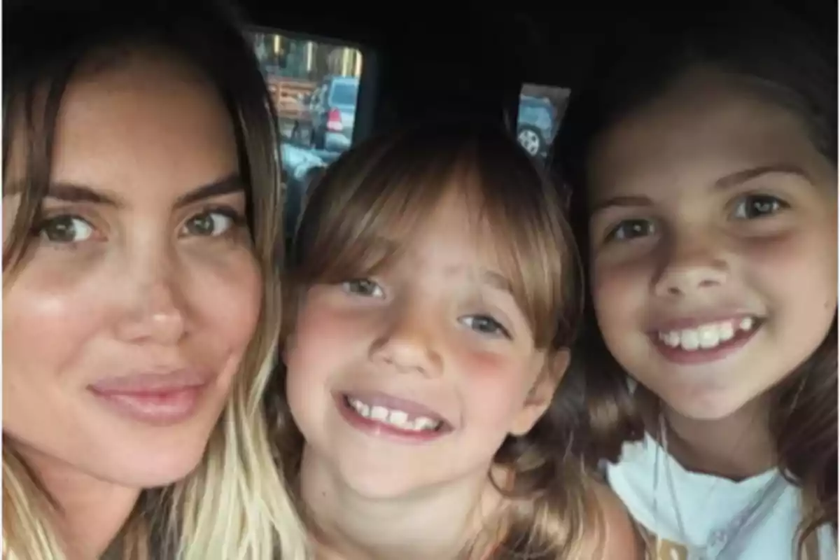 Tres personas sonríen mientras posan para una selfie dentro de un automóvil Tres personas sonríen mientras posan para una selfie dentro de un automóvil