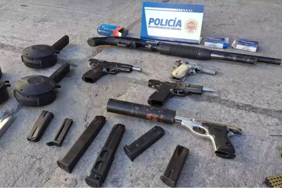 Seized firearms, magazines, ammunition, and police equipment displayed on the ground