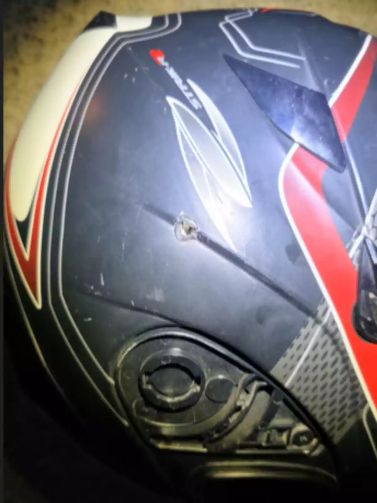Black motorcycle helmet with red and white details featuring a hole on the side. Black motorcycle helmet with red and white details featuring a hole on the side.