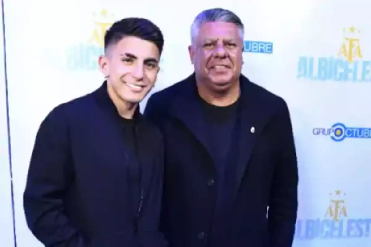 Dos personas posan sonrientes frente a un fondo con logotipos de la AFA y Grupo Octubre Dos personas posan sonrientes frente a un fondo con logotipos de la AFA y Grupo Octubre