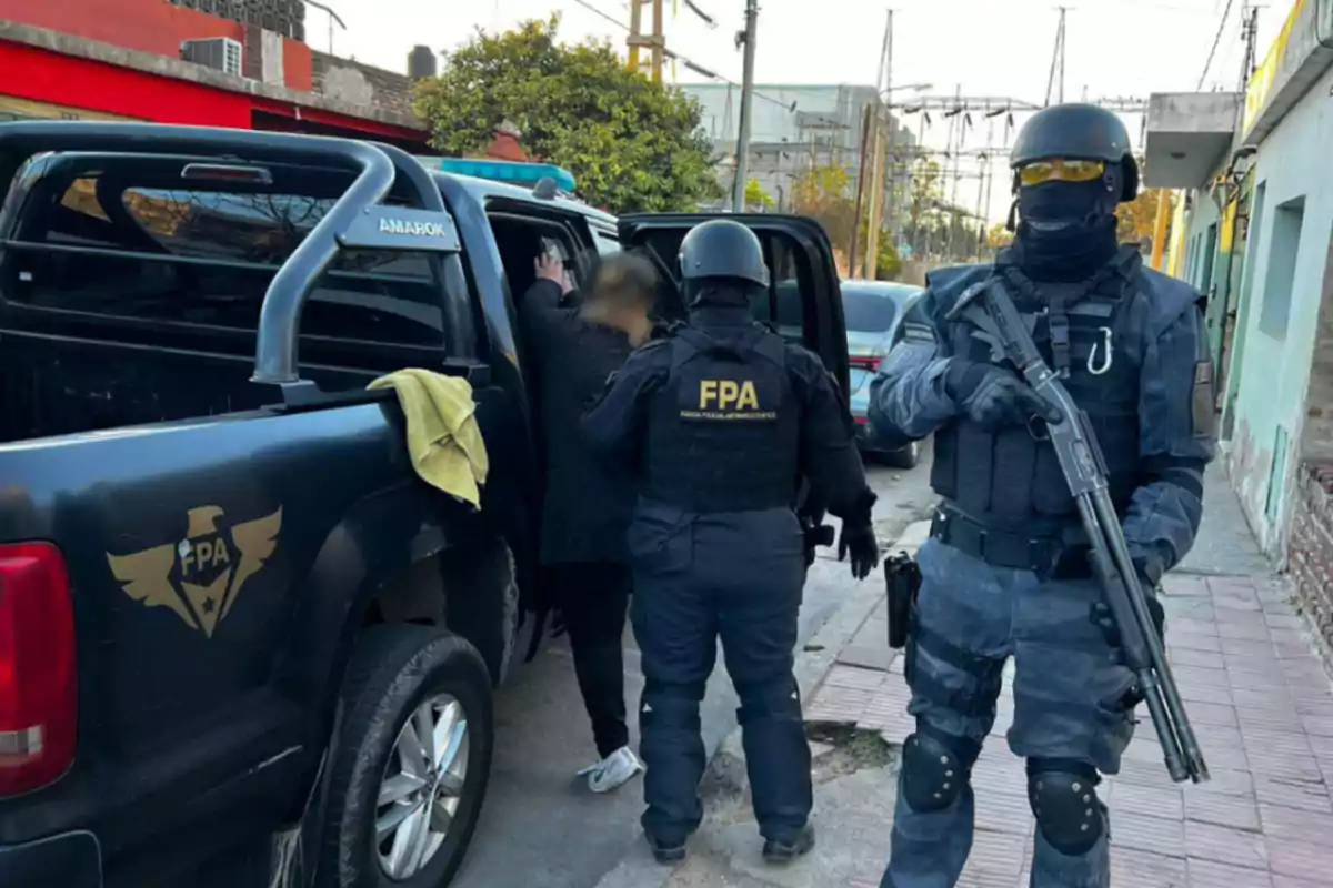 Agentes de la FPA con equipo táctico detienen a una persona y la suben a una camioneta negra en una calle urbana