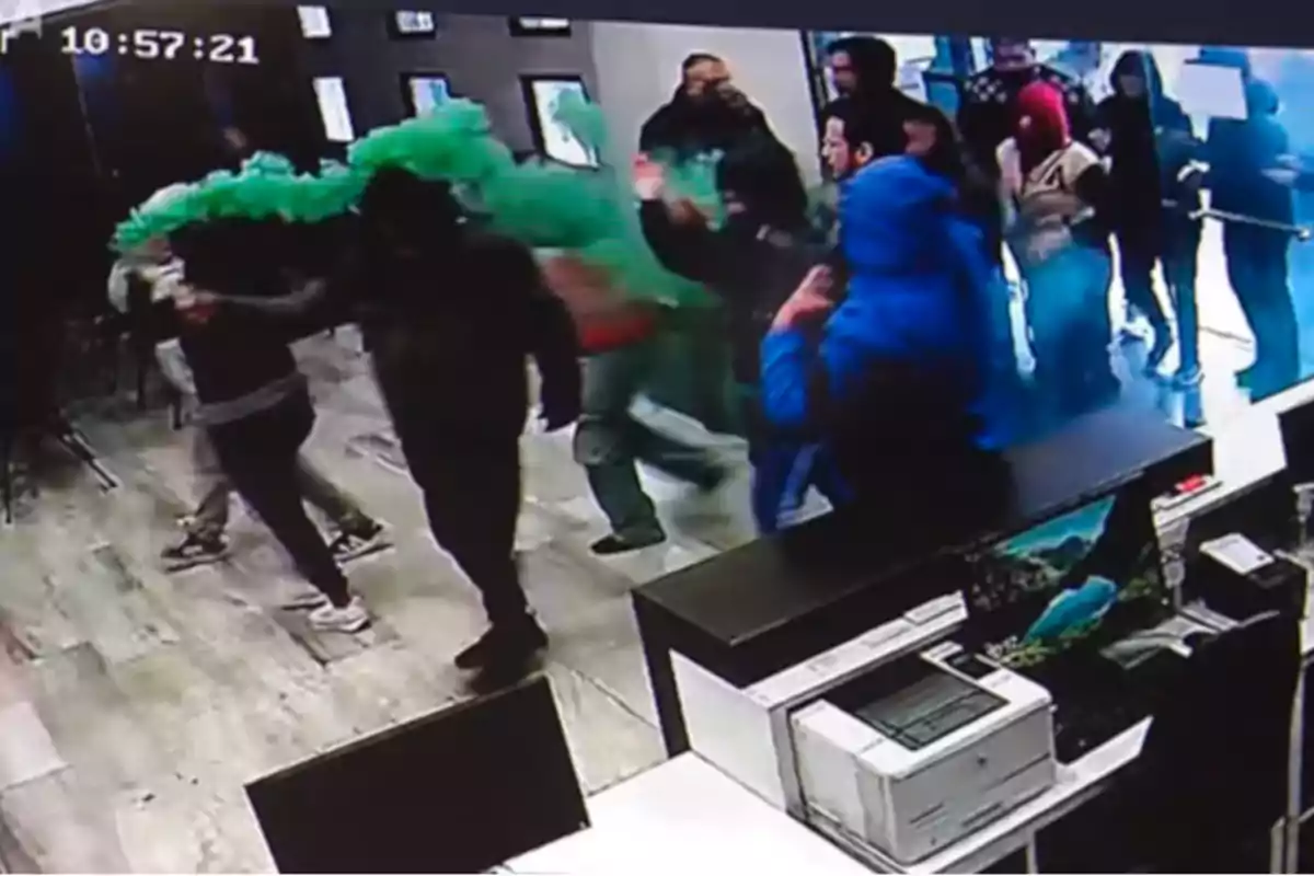 Varias personas dentro de una tienda mientras una de ellas lanza humo verde y otras observan o intentan salir Varias personas dentro de una tienda mientras una de ellas lanza humo verde y otras observan o intentan salir