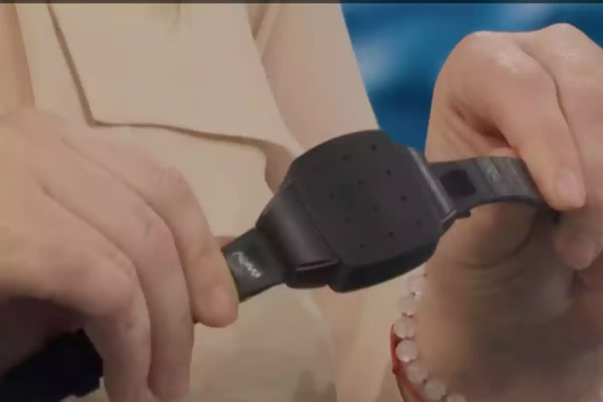 Person holding a black plastic bracelet with both hands Person holding a black plastic bracelet with both hands