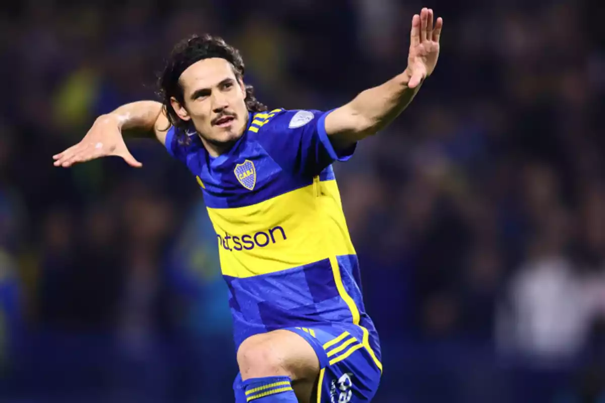 Un jugador de fútbol celebrando en el campo con uniforme azul y amarillo.