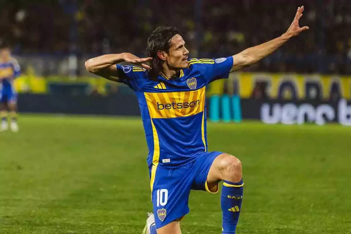 Jugador de fútbol celebrando un gol en el campo con uniforme azul y amarillo.