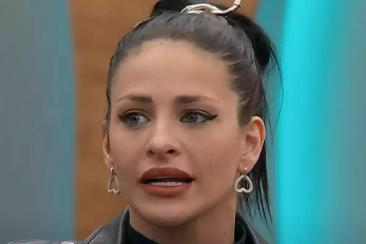 Una mujer con el cabello recogido y aretes en forma de corazón. Una mujer con el cabello recogido y aretes en forma de corazón.