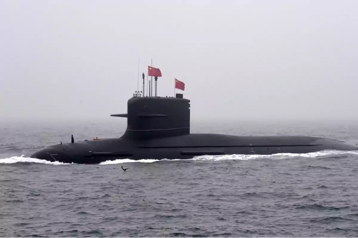 Submarino navegando en el mar con banderas rojas ondeando en la parte superior.