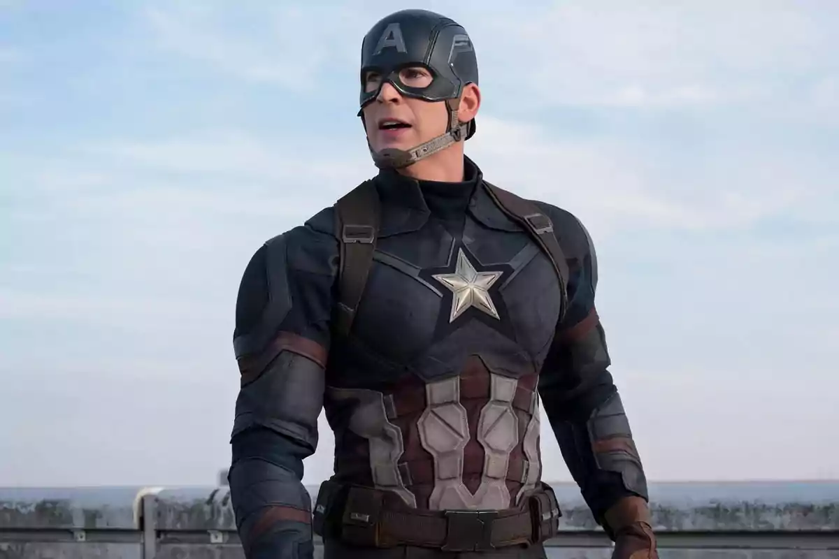 Man dressed as a superhero with a blue suit and a shield on his chest looking to the side in an outdoor setting Man dressed as a superhero with a blue suit and a shield on his chest looking to the side in an outdoor setting