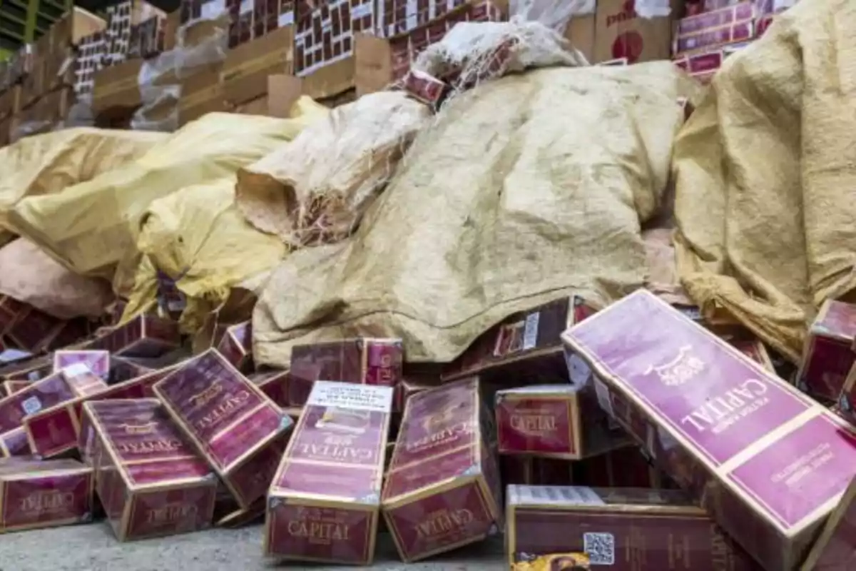 Cajas de cigarrillos apiladas y bolsas de yute en un almacén