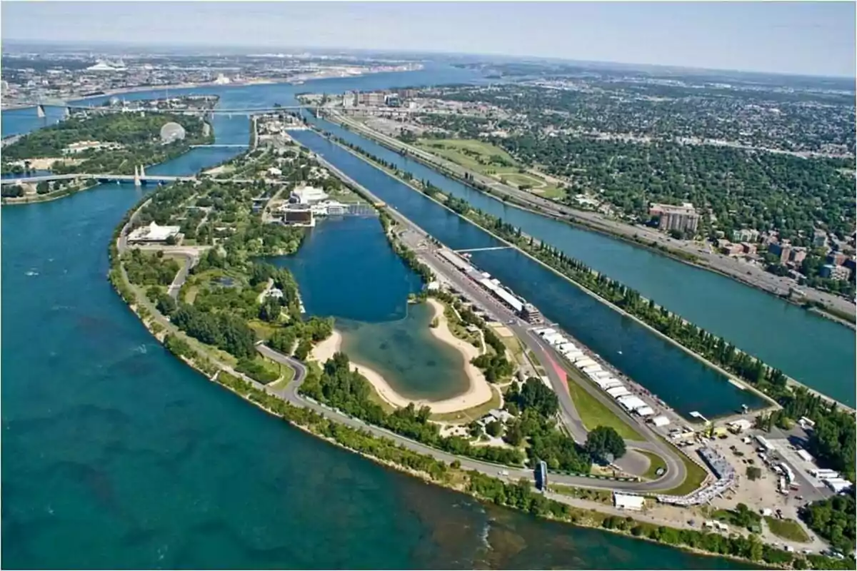 Vista aérea de una isla con un circuito de carreras rodeado de agua y áreas verdes en una ciudad. Vista aérea de una isla con un circuito de carreras rodeado de agua y áreas verdes en una ciudad.