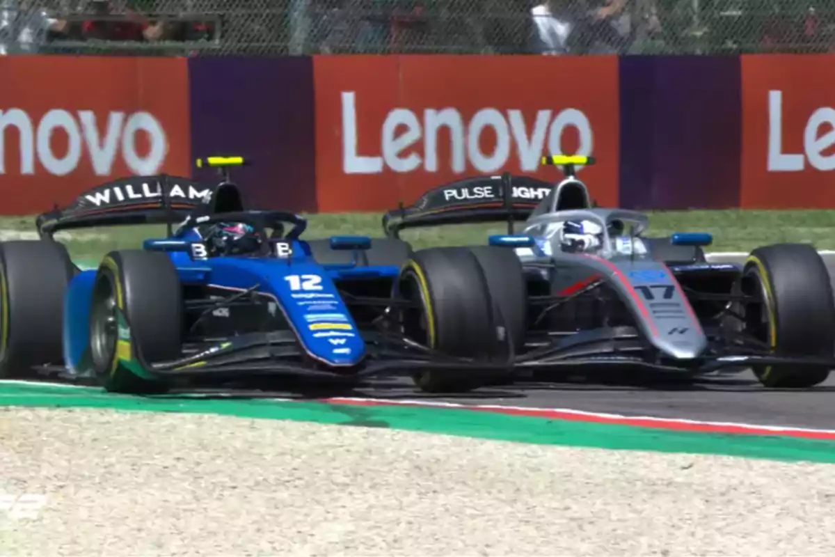 Dos autos de carreras compiten en una pista, uno azul y otro gris, con publicidad de Lenovo en el fondo. Dos autos de carreras compiten en una pista, uno azul y otro gris, con publicidad de Lenovo en el fondo.