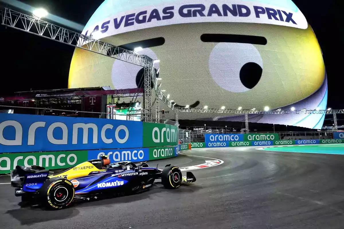 A race car on a night track with a large spherical screen in the background displaying an eye design and text. A race car on a night track with a large spherical screen in the background displaying an eye design and text.