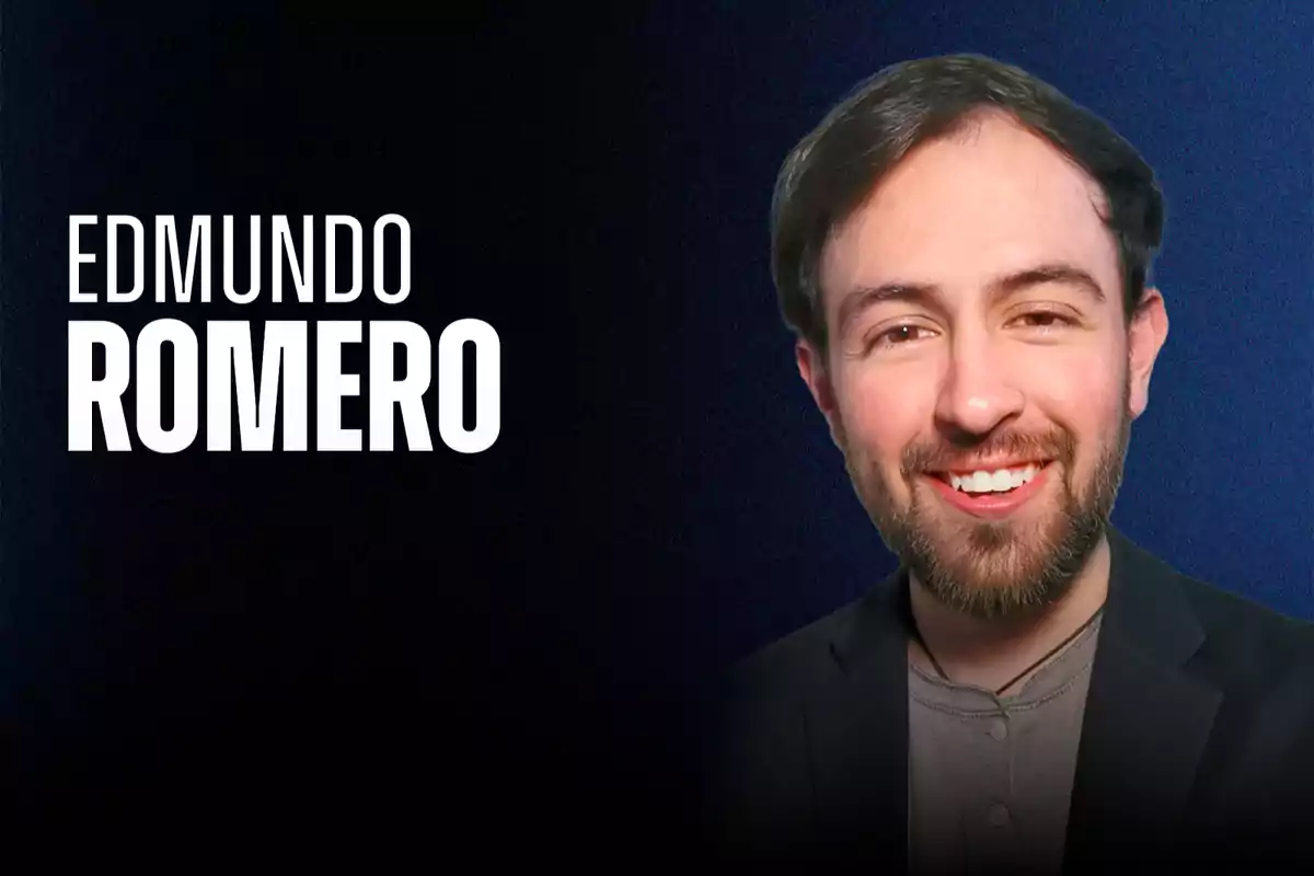 Un hombre sonriente con barba y cabello oscuro viste una chaqueta negra y una camiseta gris sobre un fondo azul oscuro con texto en letras blancas a la izquierda.