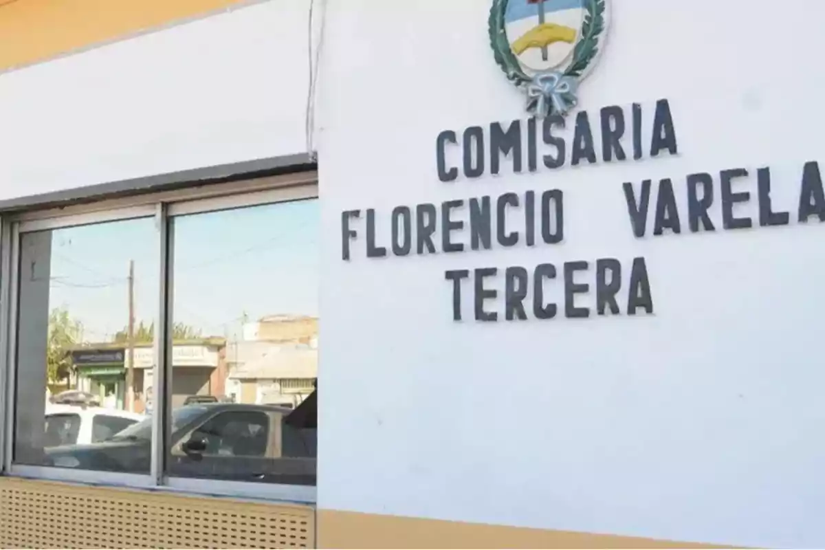 Florencio Varela Third Police Station building with a crest on the wall and a window reflecting the street.