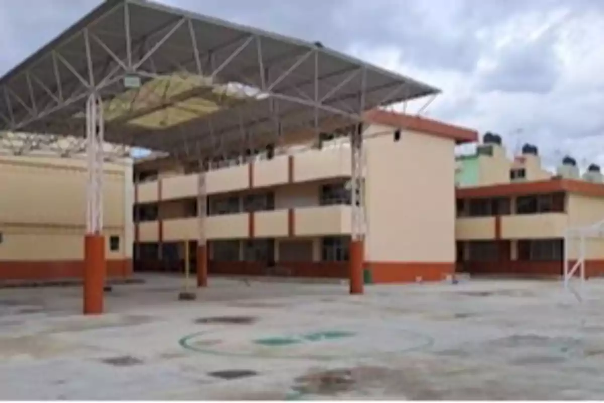 Edificio escolar de varios pisos con un patio amplio y techado.