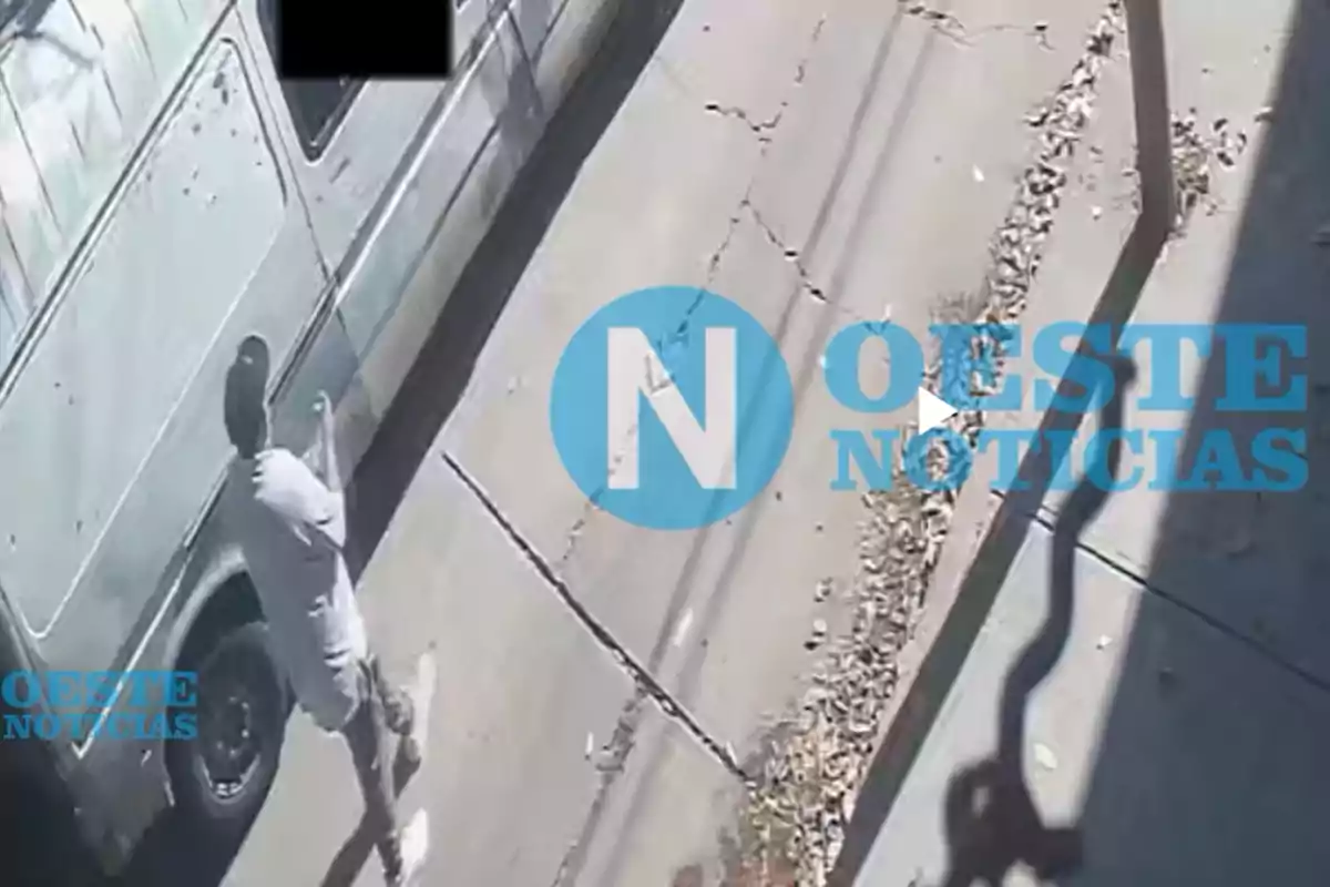 Un hombre de pie junto a una camioneta en una calle con pavimento agrietado y hojas secas en el suelo. Un hombre de pie junto a una camioneta en una calle con pavimento agrietado y hojas secas en el suelo.
