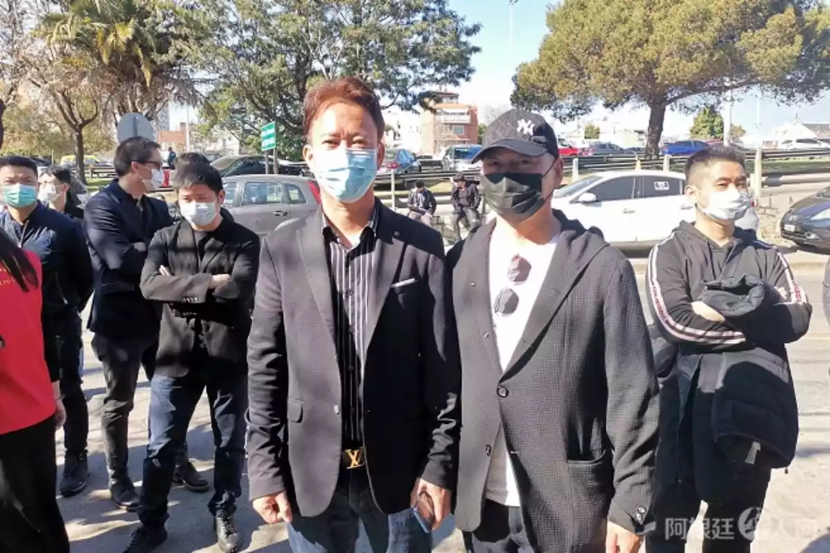 Un grupo de personas con mascarillas en un entorno al aire libre.