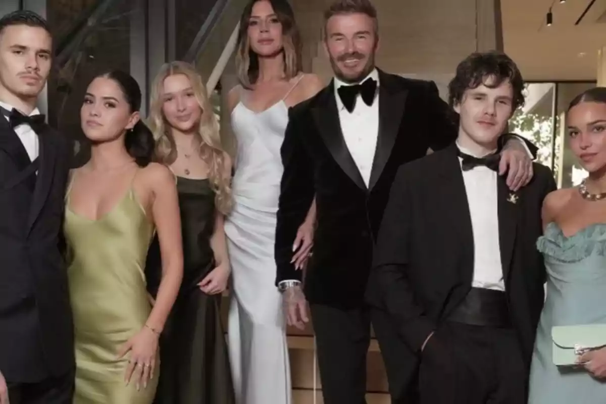 A group of elegantly dressed people posing together at a formal event. A group of elegantly dressed people posing together at a formal event.