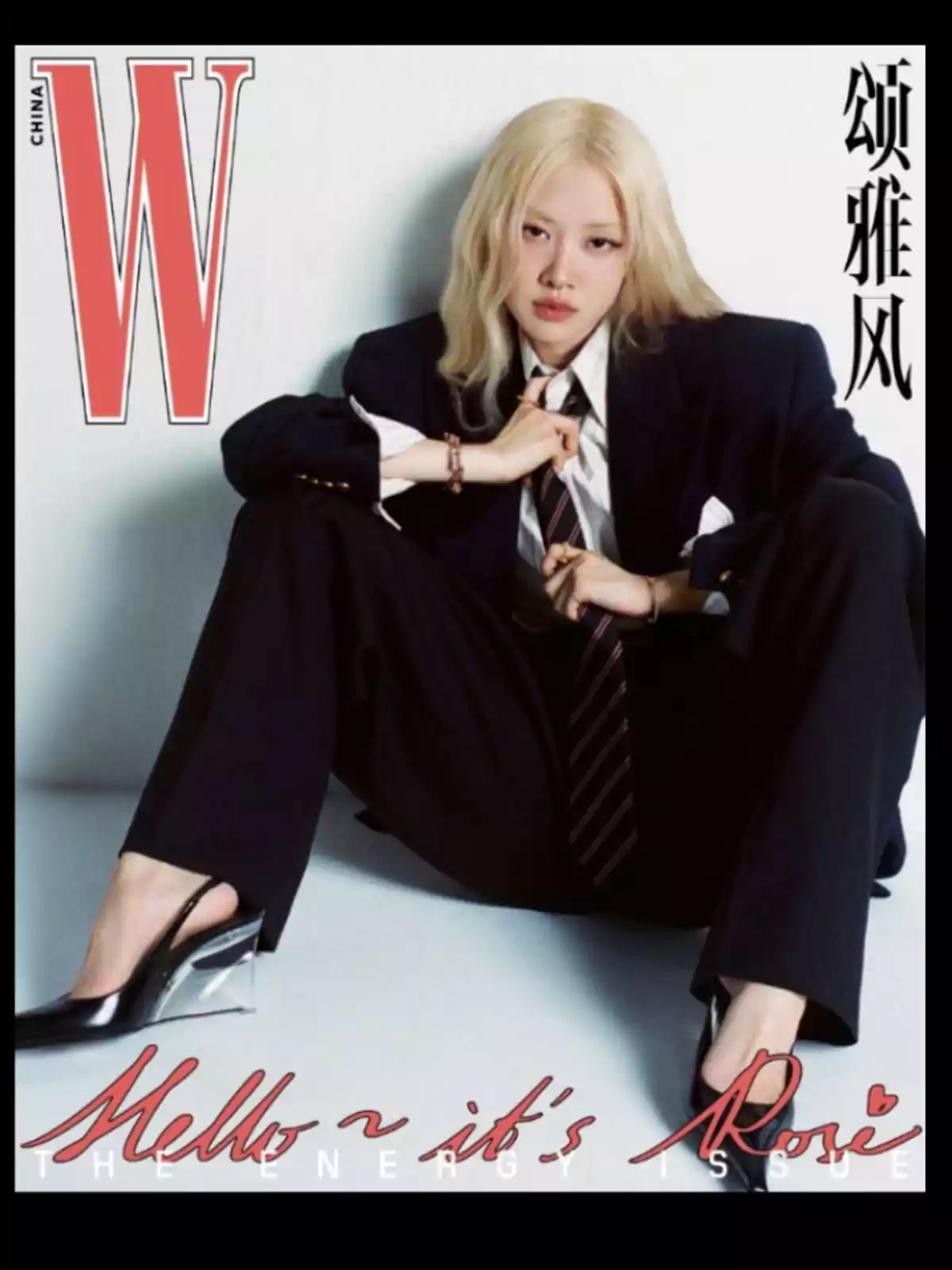 A person with blonde hair and a dark suit poses sitting on the floor for a magazine cover, with the A person with blonde hair and a dark suit poses sitting on the floor for a magazine cover, with the