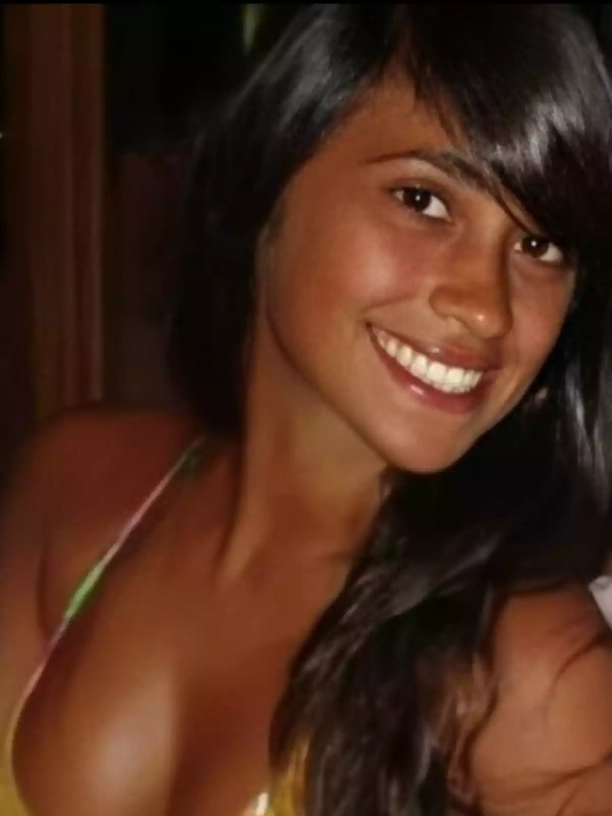A smiling person with long dark hair, wearing a sleeveless top. A smiling person with long dark hair, wearing a sleeveless top.