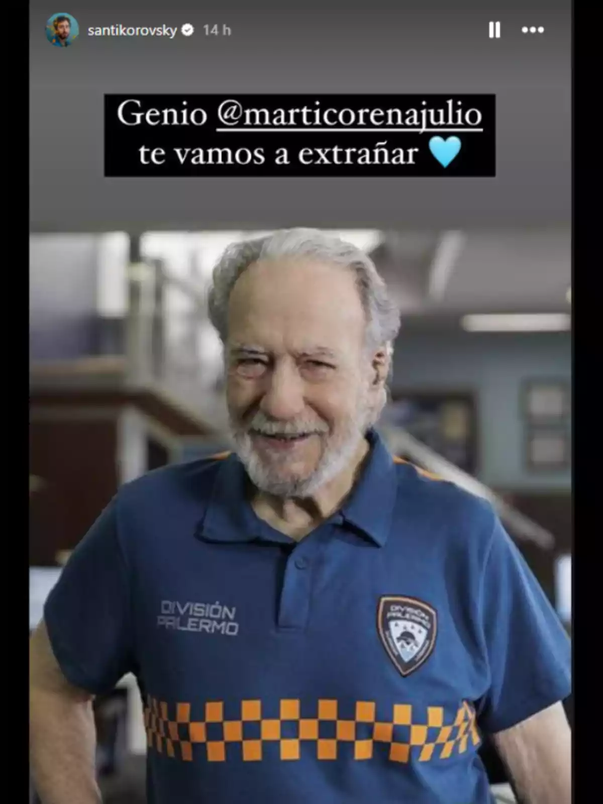 An older man smiles while wearing a blue t-jersey with the An older man smiles while wearing a blue t-jersey with the