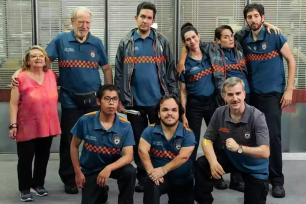 A group of people posing together, some standing and others crouching, all wearing uniforms with an orange and blue checkered design. A group of people posing together, some standing and others crouching, all wearing uniforms with an orange and blue checkered design.