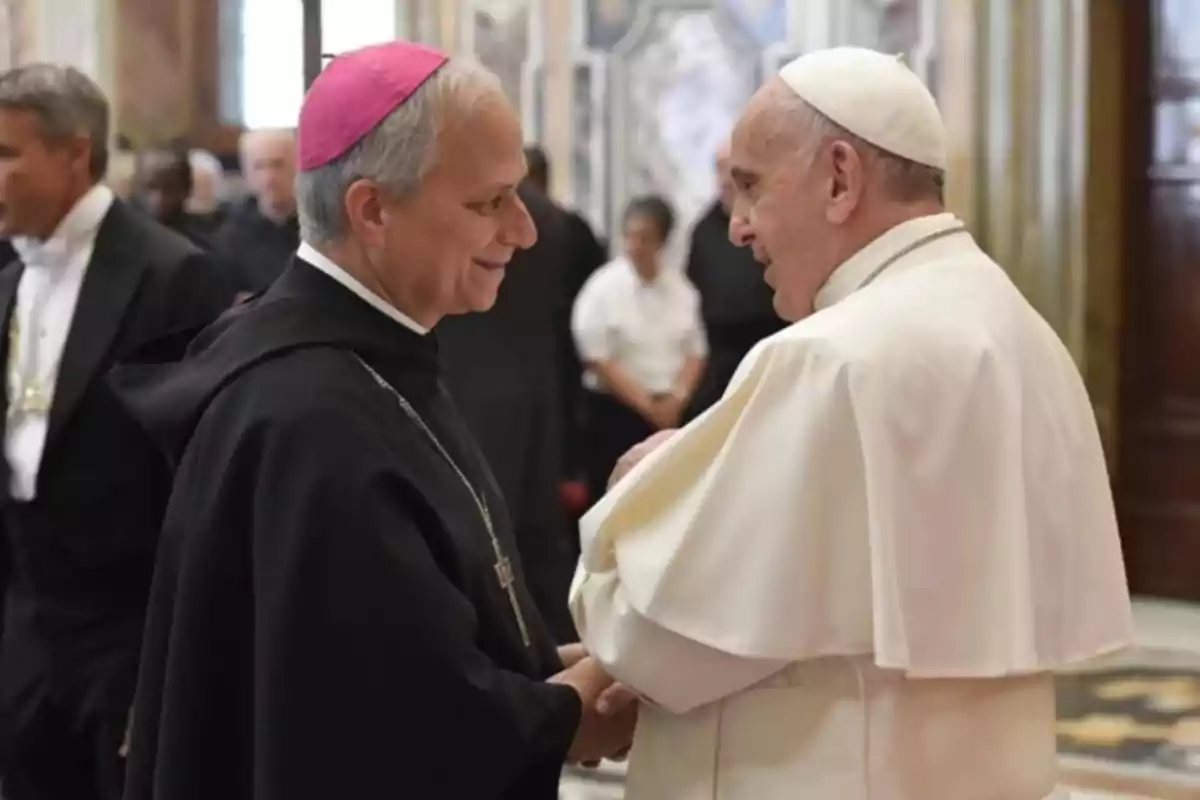 Dos líderes religiosos conversan y se saludan cordialmente en un entorno formal.