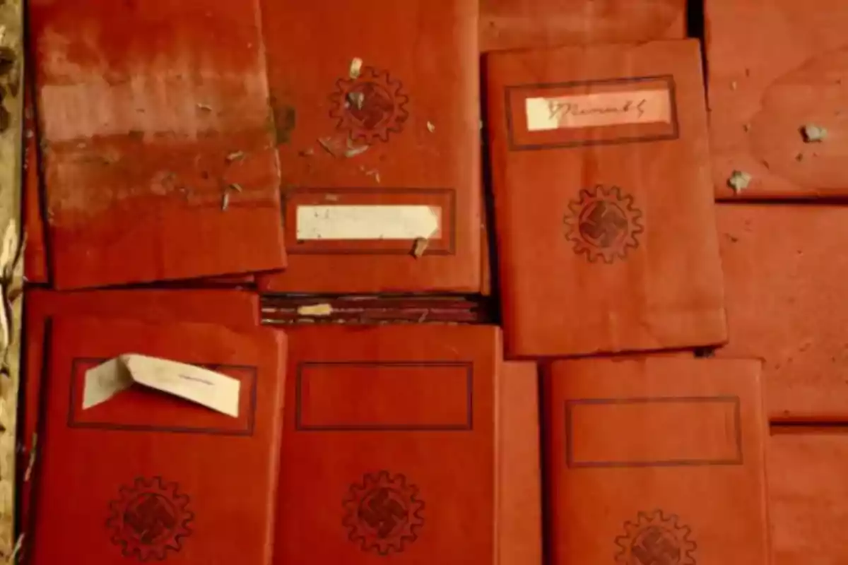 Varios cuadernos rojos apilados con símbolos y etiquetas en la portada. Varios cuadernos rojos apilados con símbolos y etiquetas en la portada.