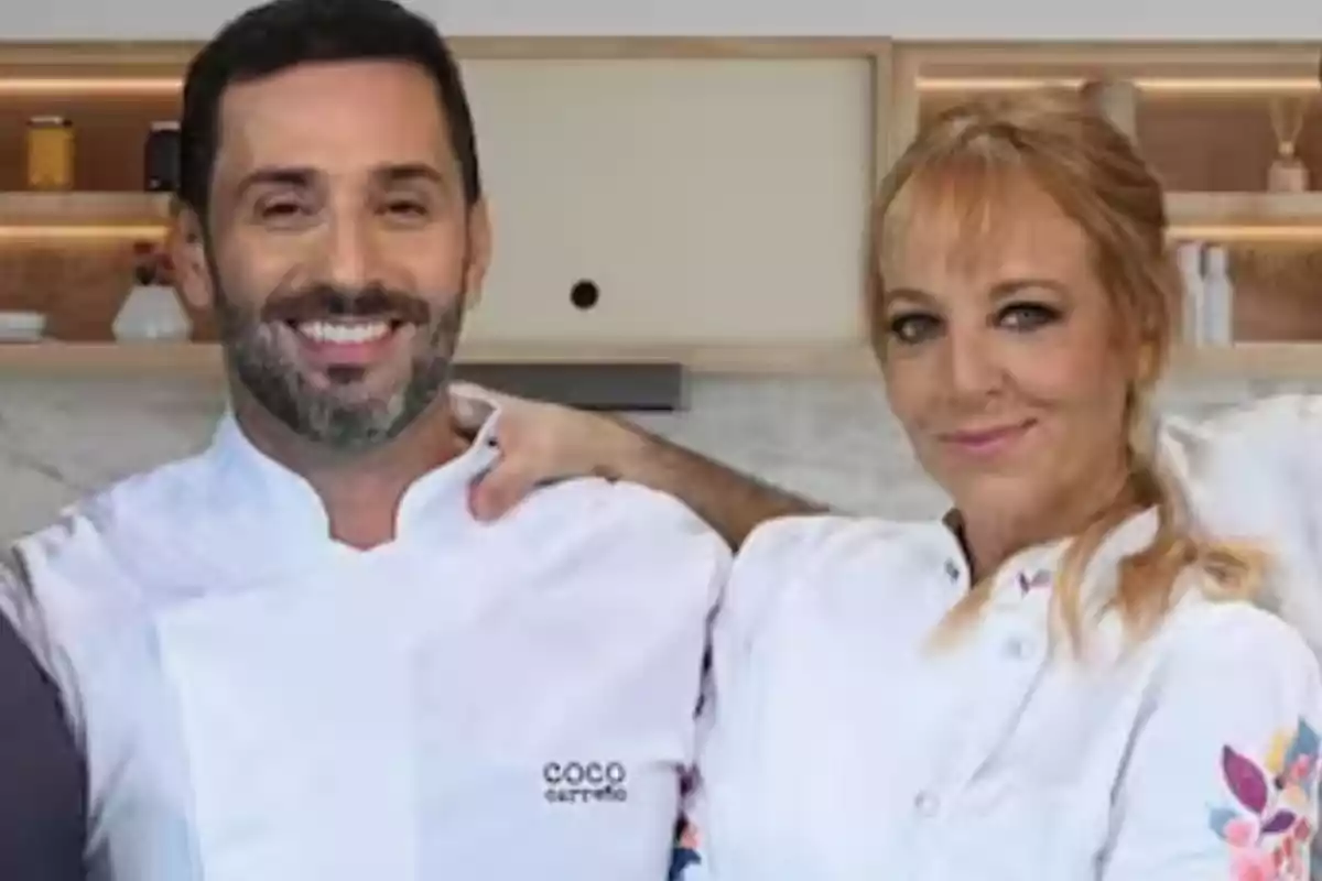 Dos personas sonriendo con uniformes de chef en una cocina moderna. Dos personas sonriendo con uniformes de chef en una cocina moderna.