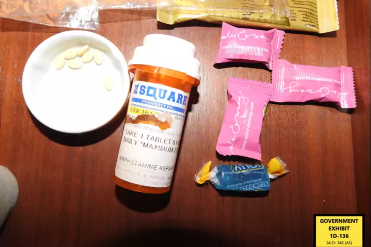 A jar of pills next to several candies on a wooden surface. A jar of pills next to several candies on a wooden surface.