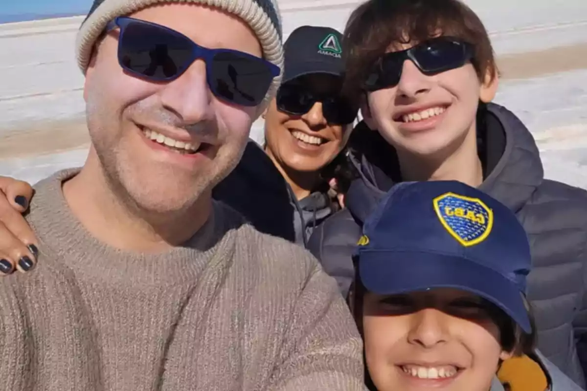 Familia sonriente tomándose una selfie al aire libre en un lugar soleado y nevado