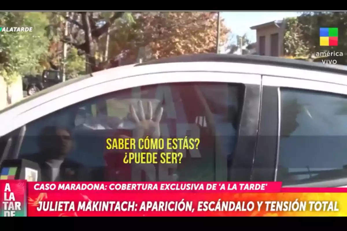 Person inside a car with their hand resting on the window while yellow text appears that says 
