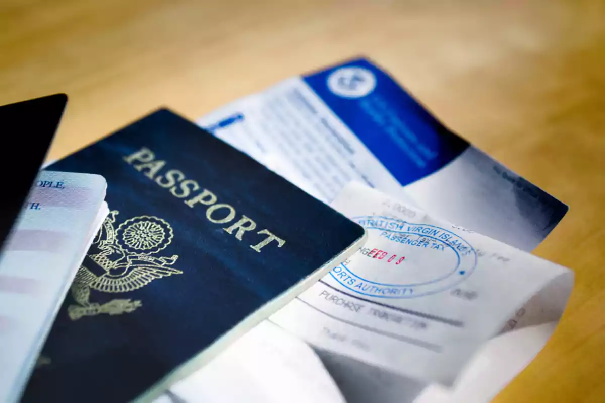 Pasaporte estadounidense junto a documentos de viaje y boletos sobre una mesa Pasaporte estadounidense junto a documentos de viaje y boletos sobre una mesa