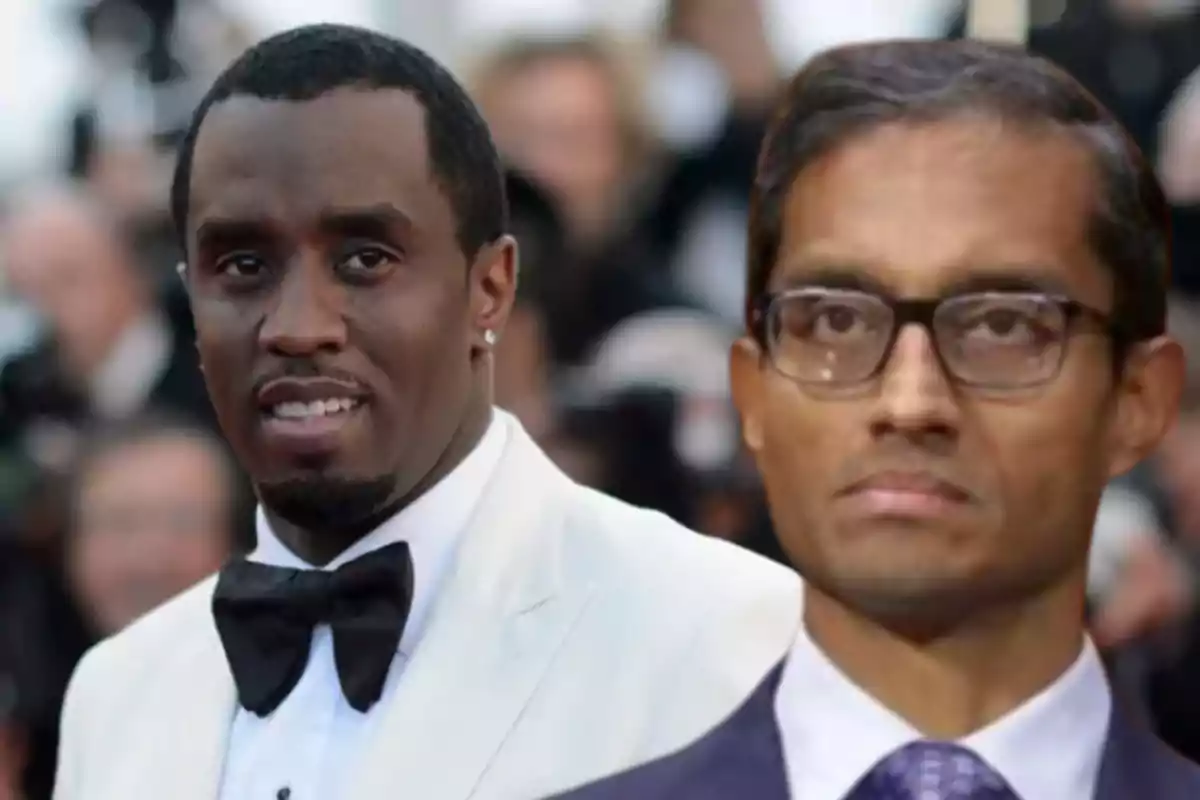 Dos hombres posan en un evento formal, uno lleva esmoquin blanco y el otro usa gafas y traje oscuro