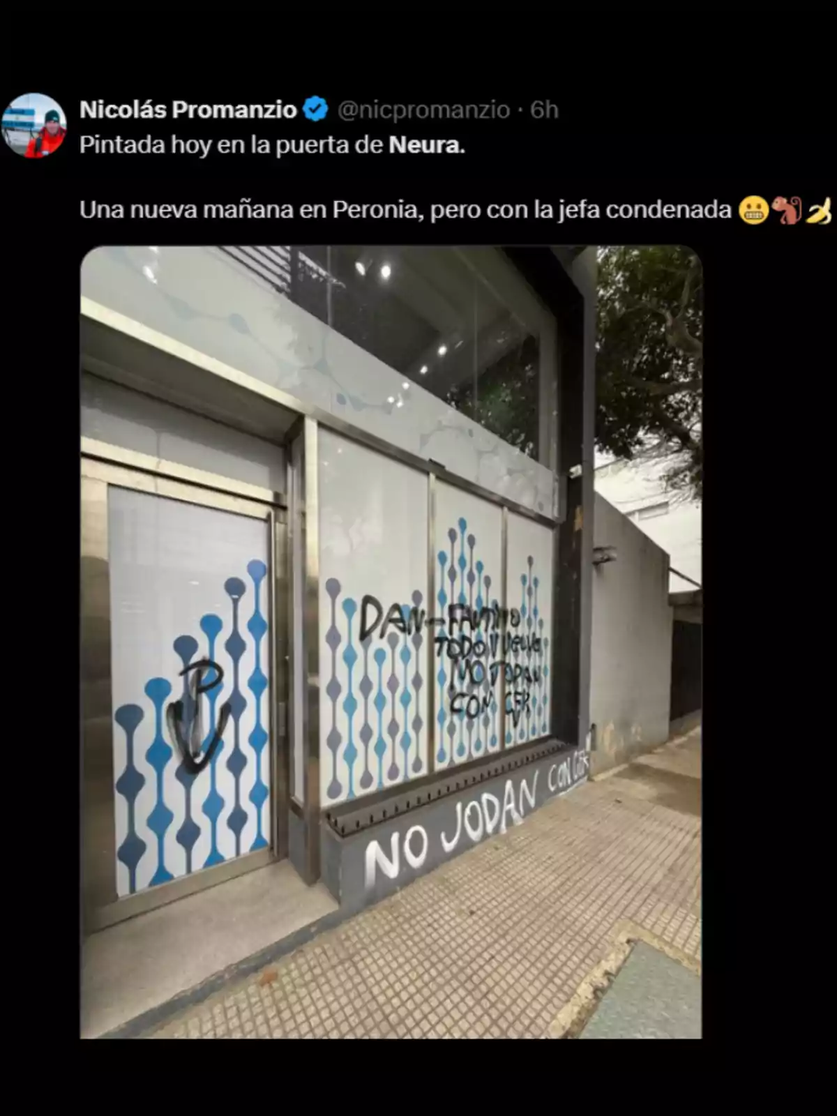 Fachada de un local con vidrios decorados y pintadas en aerosol negro y blanco con mensajes y símbolos, incluyendo la frase Fachada de un local con vidrios decorados y pintadas en aerosol negro y blanco con mensajes y símbolos, incluyendo la frase