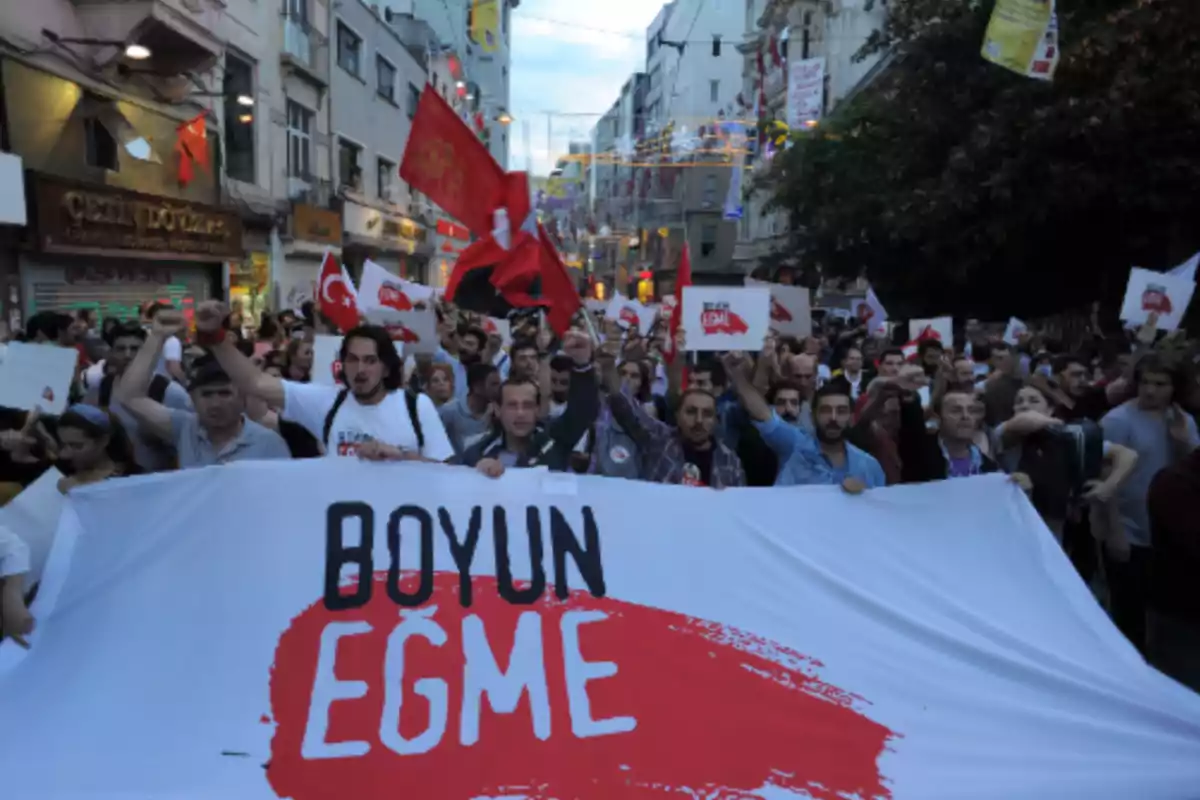 Mass demonstration on a street with people holding signs and a large banner that says Mass demonstration on a street with people holding signs and a large banner that says