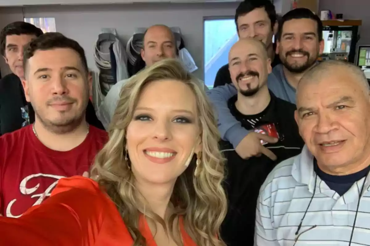 Grupo de personas sonriendo y posando para una selfie en un ambiente interior Grupo de personas sonriendo y posando para una selfie en un ambiente interior