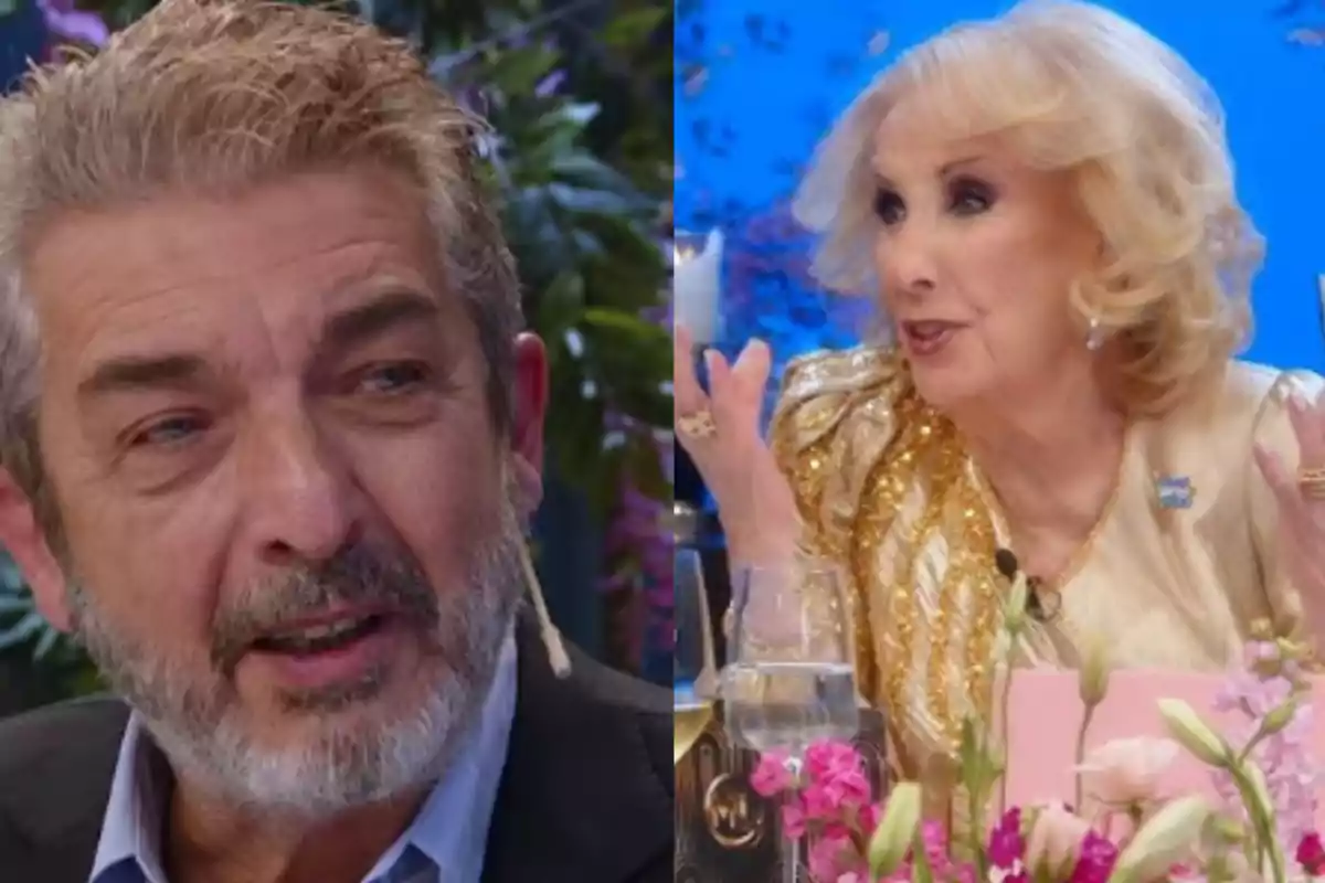 A gray-haired, bearded man talks with an elegantly dressed blonde woman in a TV show setting with flowers and glasses on the table. A gray-haired, bearded man talks with an elegantly dressed blonde woman in a TV show setting with flowers and glasses on the table.