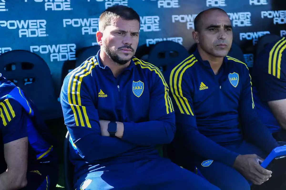 Dos entrenadores de Boca Juniors sentados en el banco de suplentes con expresión seria durante un partido Dos entrenadores de Boca Juniors sentados en el banco de suplentes con expresión seria durante un partido