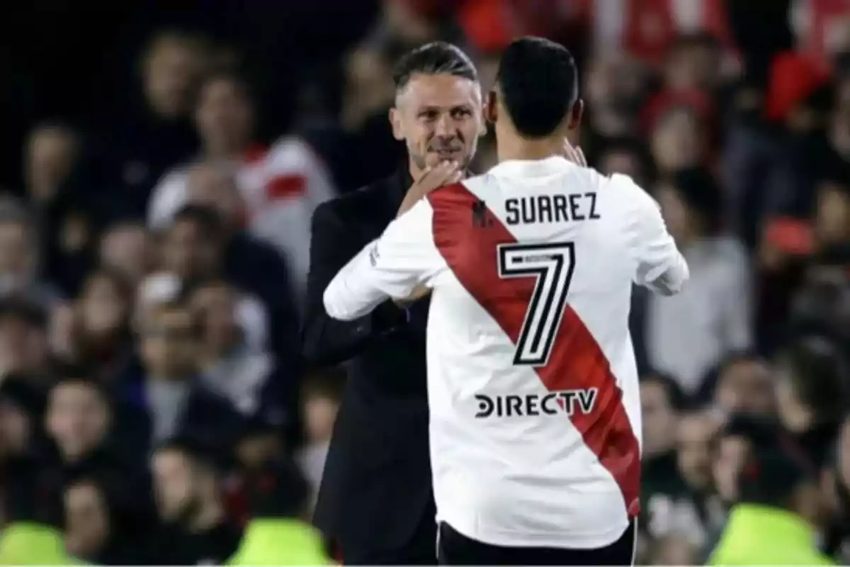 Entrenador y jugador de River Plate se saludan en el campo durante un partido Entrenador y jugador de River Plate se saludan en el campo durante un partido