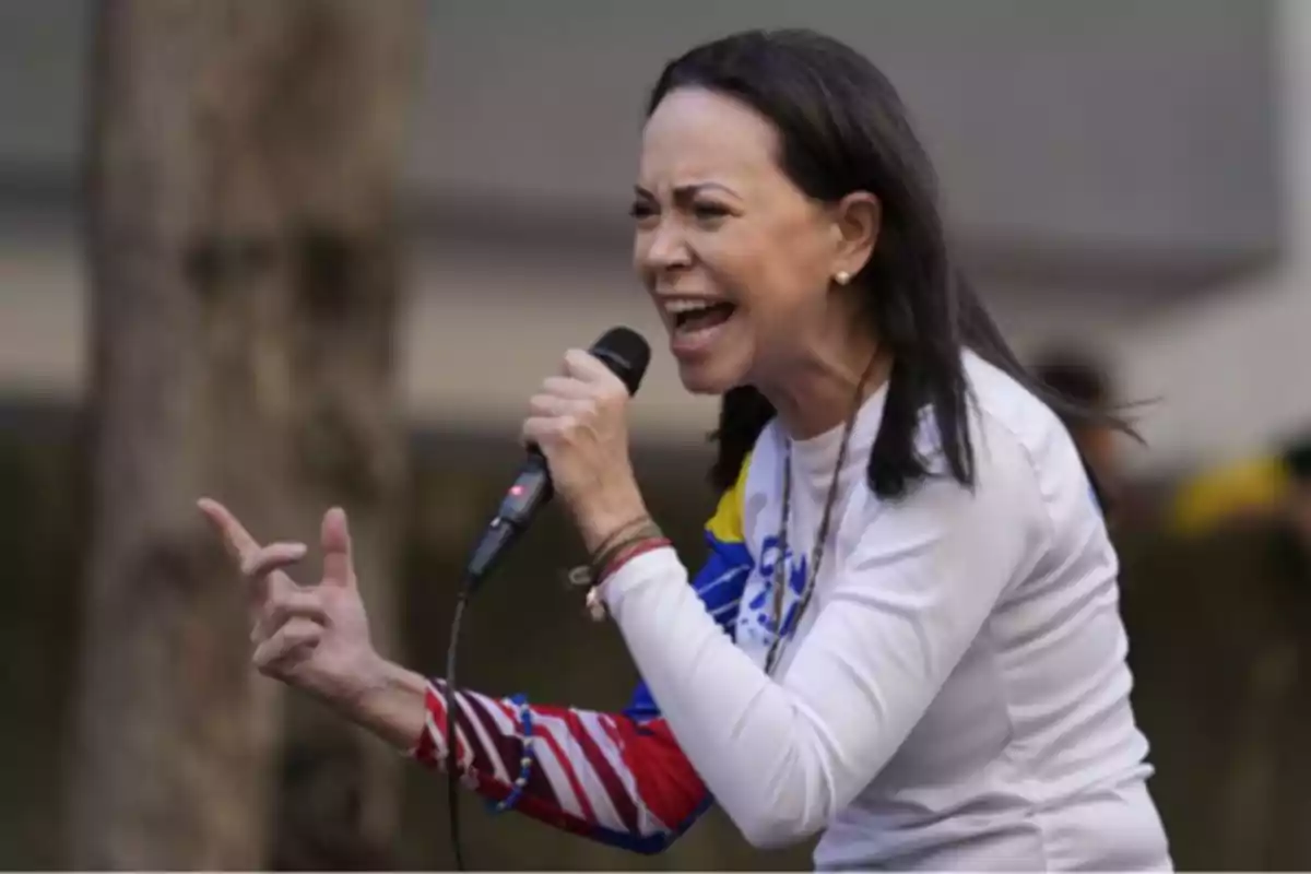 Mujer hablando apasionadamente con un micrófono en la mano durante un evento al aire libre.