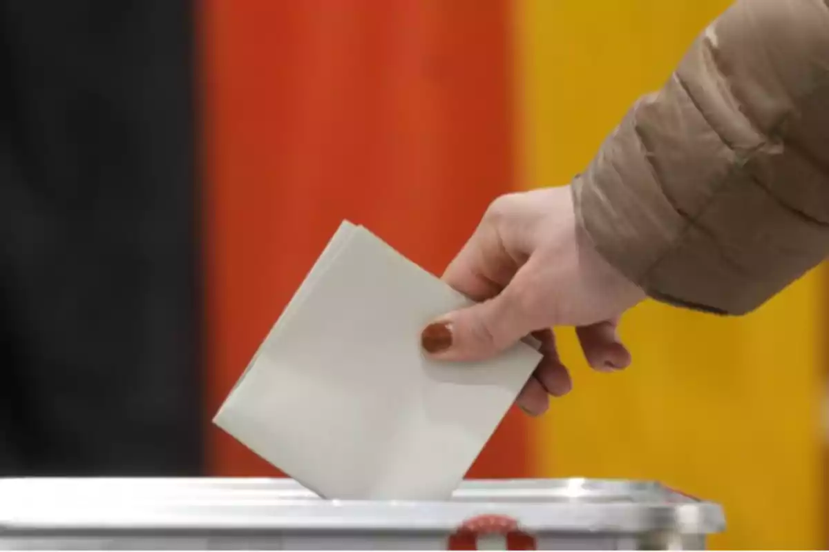 Persona depositando un voto en una urna durante una elección.