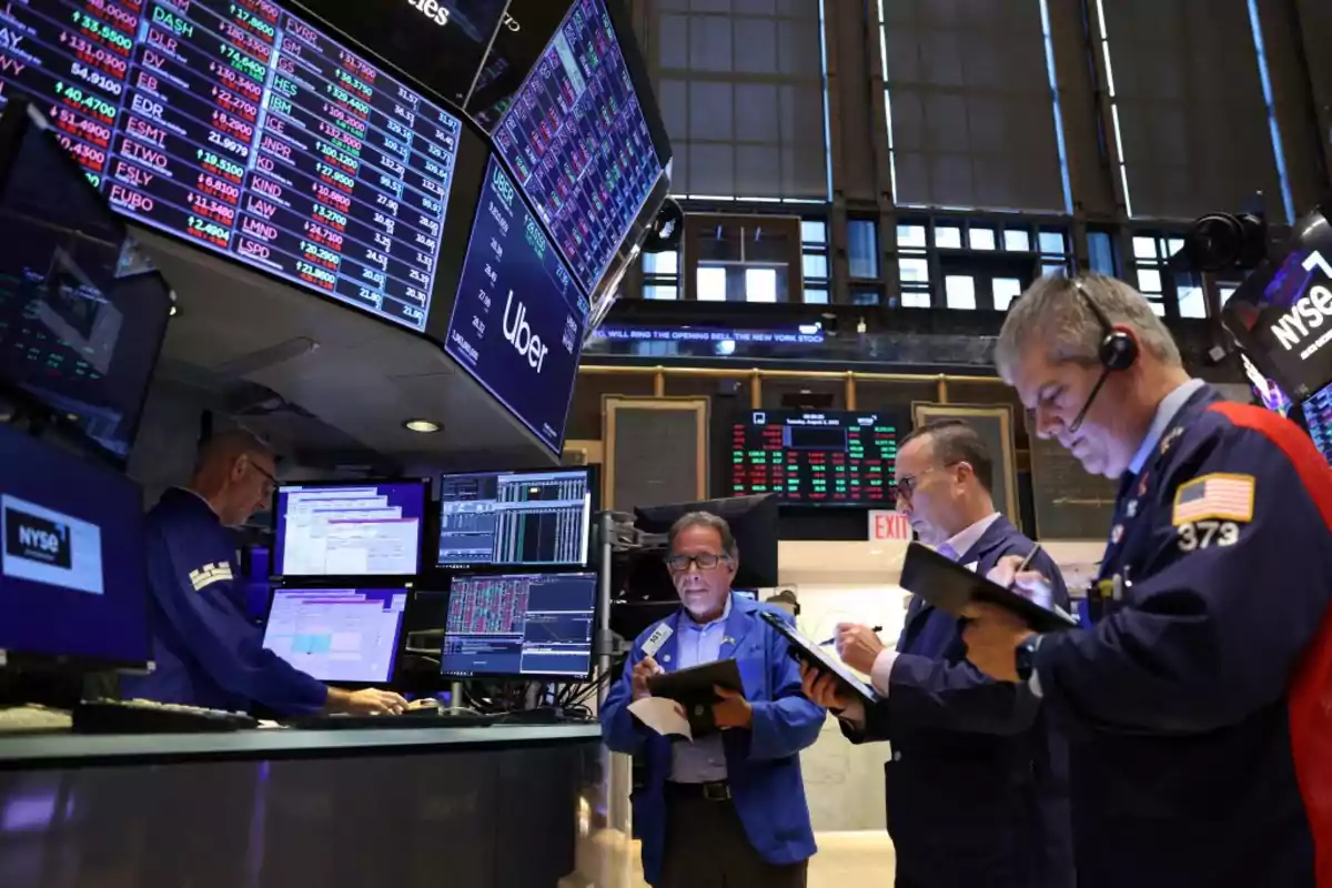 People working on the New York Stock Exchange, surrounded by screens with financial information.