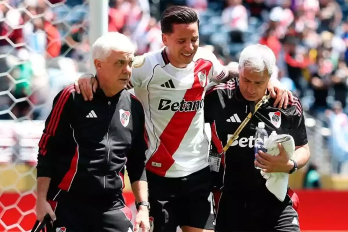 River Plate player is assisted by the medical staff while leaving the field with a pained expression.