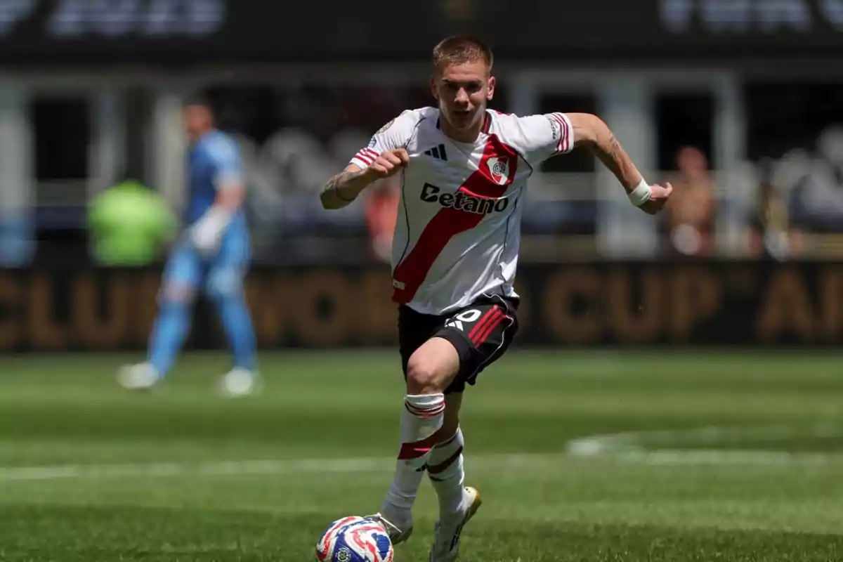 River Plate player running with the ball during a match in a soccer stadium River Plate player running with the ball during a match in a soccer stadium