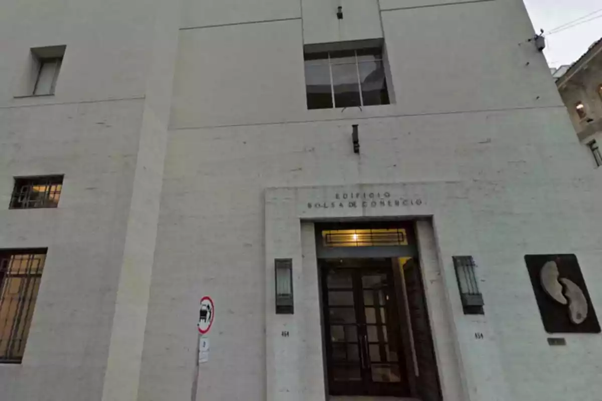 Entrance of a building with a light stone facade and a sign that says Entrance of a building with a light stone facade and a sign that says