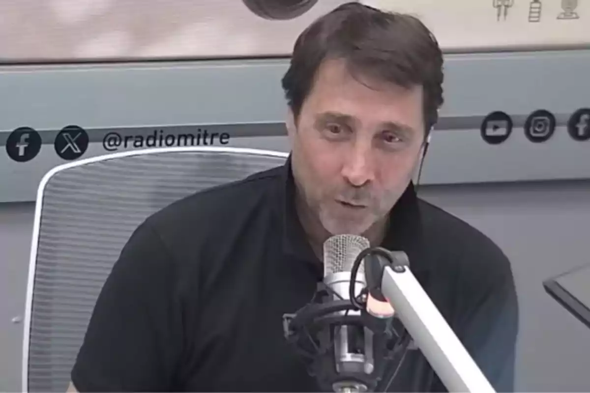 Hombre hablando frente a un micrófono en un estudio de radio.