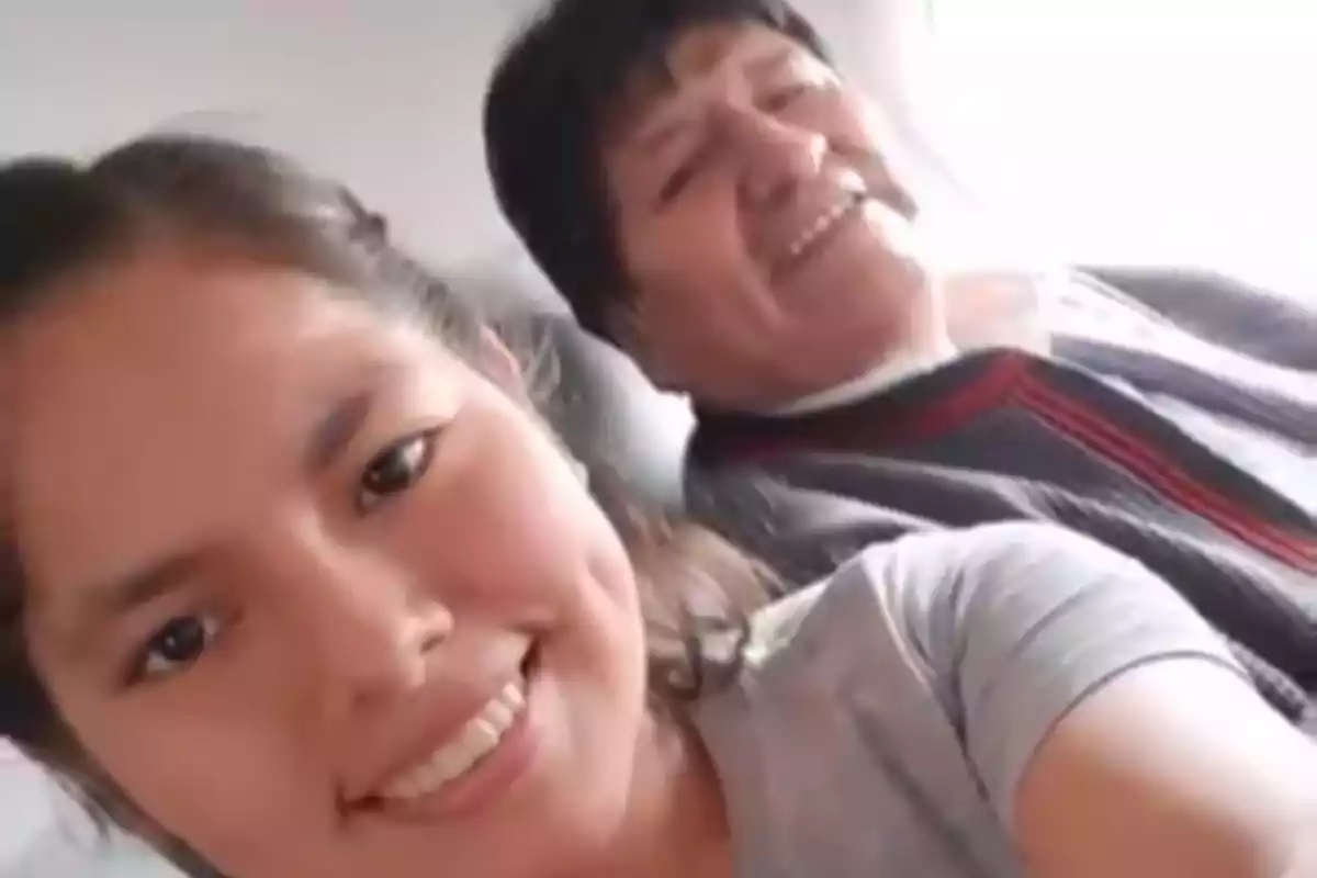 Dos personas sonríen mientras se toman una selfie en un lugar iluminado. Dos personas sonríen mientras se toman una selfie en un lugar iluminado.